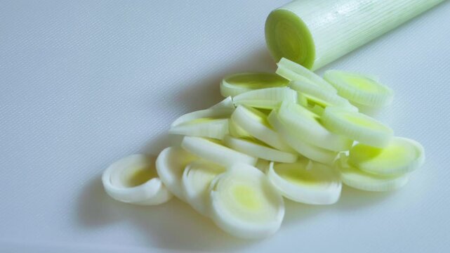 Close-up. Sliced, leeks piled on a white kitchen board.