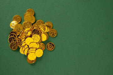 St Patricks day concept with golden coins on green background. View from above. Copy space. Festive...