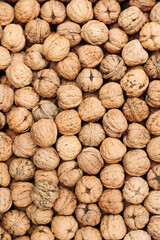 Pile of whole walnuts with textured shells. Natural organic nuts. Textured pile of whole walnuts with rough natural shells, creating an organic and rustic food composition