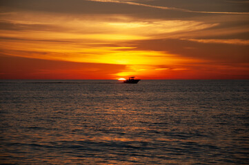 Fischerboot im gelb orangenen Sonnenuntergang