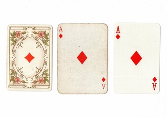 Three vintage playing cards of the same vale in different designs on a white background.