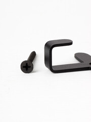 Close-up of two black cross-head screws lying on a white surface