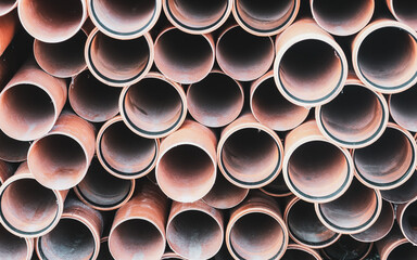 Image of a stack of plastic sewer pipes neatly arranged, perfect for industrial, construction, and...