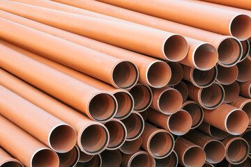 Image of a stack of plastic sewer pipes neatly arranged, perfect for industrial, construction, and infrastructure projects.