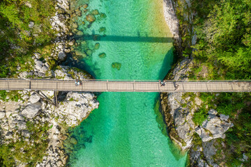 A suspension bridge spans the emerald waters of the Soca River in Slovenia