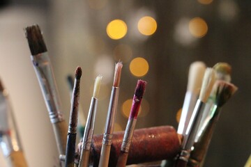 close-up of various paintbrush heads standing in front of an illuminated background