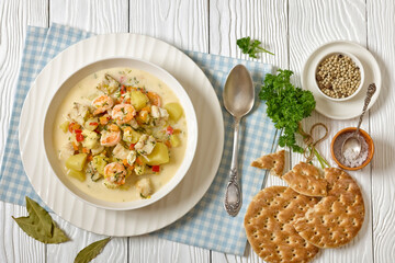 seafood chowder in a white bowl, top view