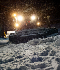 Snowcat preparing a slope at night in high mountains at skiing resort of the North Caucasus Elbrus