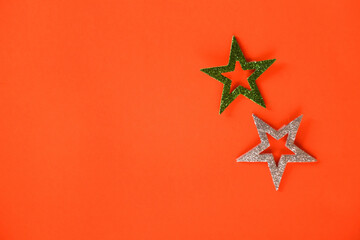 Season's greetings scene. Origami stars, sparkling stars on a orange background. Flat lay. orange backdrop text or ad space
