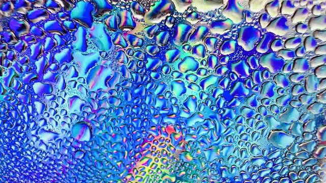 Close-up of water drops on metal surface in high resolution showing condensation of water droplets on metal surface. Intricate patterns and different sized water droplets create a beautiful abstract