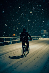 Obraz premium A man is riding a bicycle down a snowy street at night