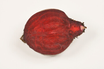 A top-down shot of a single, halved beet root against a plain background, showcasing its deep red...