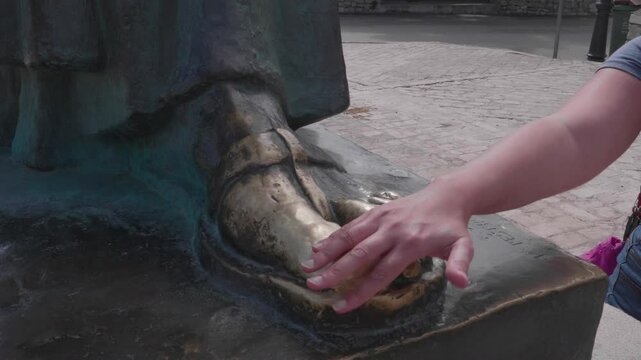 Hand rubbing the golden toe of Grgur Ninski Statue, Nin, Croatia