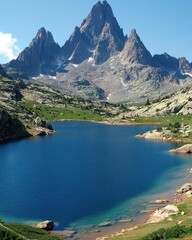 Serene alpine lake nestled beneath majestic mountain peaks on a sunny day.
