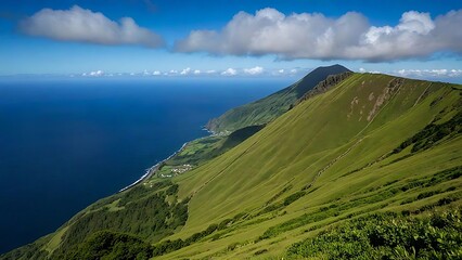 Fototapeta premium Coastal Mountain Vista: Ocean, Green Slopes, and Clouds