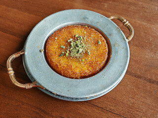 Turkish dessert kunefe, kunafa, kadayif with pistachio powder and cheese hot eaten sweet