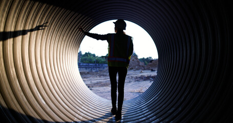 Female Maintenance and Inspection of Waterworks and Irrigation Utilities Equipment Materials and Workers using walkie-talkie to communicate with her team at the sewage  under  construction