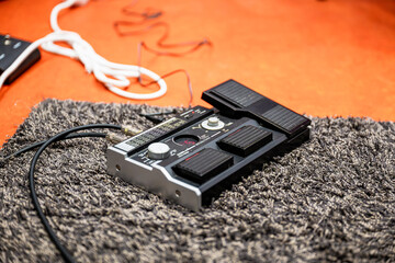 Close-up of a guitar effects processor with knobs and footswitch in a music studio