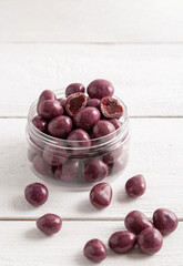Dried fruits in chocolate glaze. Candies in a glass jar.