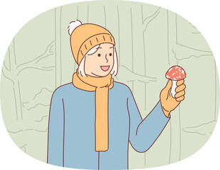 Woman mushroom picker found toadstool in forest and risks becoming victim poisonous fungus. Dangerous fly agaric in hands mushroom picker girl who went on hike to collect wild funguses and berries