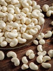Cashew nuts in milk chocolate on a brown wooden background. Close-up.