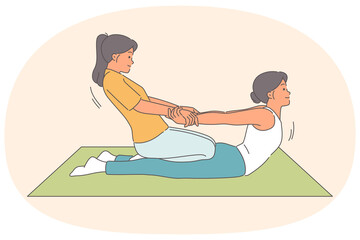 Obraz premium Thai massage for woman lying on floor, from girl masseur pulling patient hands to straighten spine