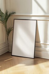 Charming interior showcasing a framed poster resting elegantly on hardwood floor against a wall adorned with delicate sunlight patterns
