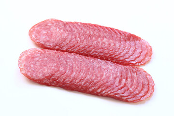 Thinly sliced ​​salami sausage close-up. Side view of tasty sliced ​​sausage. Appetizer. Sausage on white background