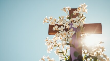 Christian Easter decorations featuring a rustic wooden cross adorned with fresh white lilies and a purple cloth set against a bright blue sky in natural sunlight