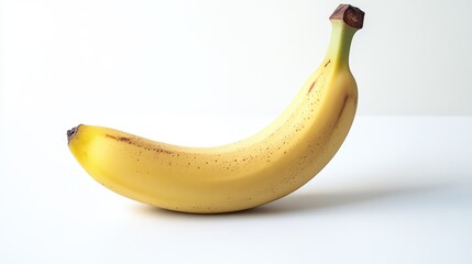 Ripe banana with slight curve on plain white background for minimalist presentation