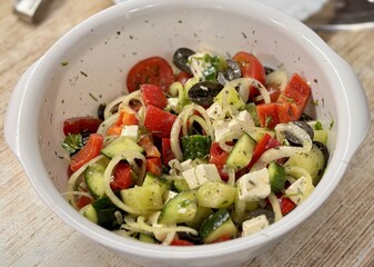 A vibrant Mediterranean salad featuring tomatoes, cucumbers, olives, and feta cheese, perfect for any meal. Close-up