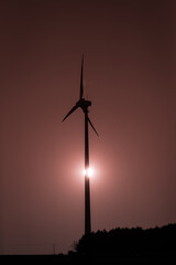 Turbina wiatrowa z zachodzącym słońcem w tle © kubikactive