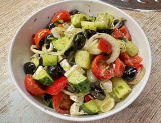 A vibrant Mediterranean salad featuring tomatoes, cucumbers, olives, and feta cheese, perfect for any meal. Close-up