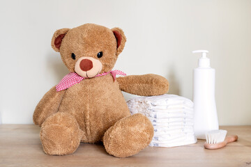 Stack of diapers with toy teddy bear on table.Newborn nappies concept