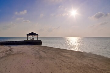 Romantic wooden gazebo overlooking tranquil ocean at sunset in maldives