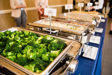 Broccoli in a metal serving tray.