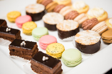 Arrangement of chocolate cake, colorful macaroons, and other desserts.