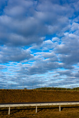 Blue sky and delicate clouds over the highway. The photo was taken on a sunny day.