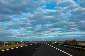 Fototapeta premium Blue sky and delicate clouds over the highway. The photo was taken on a sunny day.