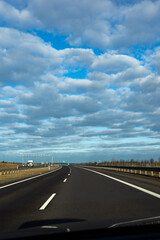 Fototapeta premium Blue sky and delicate clouds over the highway. The photo was taken on a sunny day.