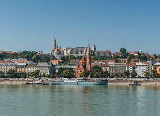 Obraz premium panorama of buda bastion with many roofs over the danube river and hills behind