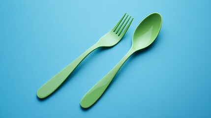 Bright Green Plastic Fork and Spoon on Blue Background