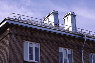 A person standing at the edge of a rooftop with cityscape in the background.