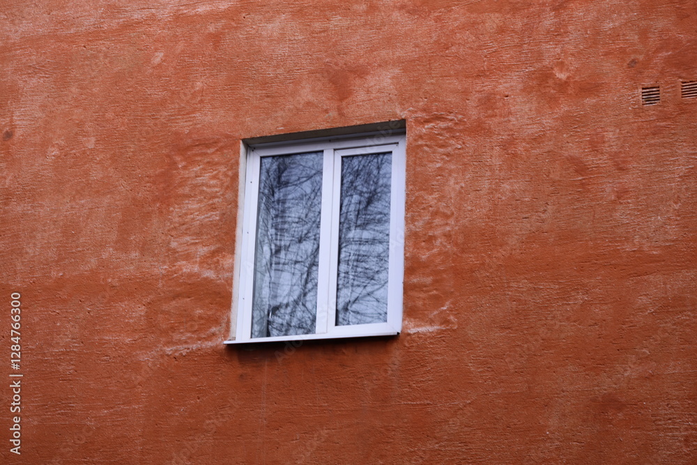 Aufkleber A window on a red building with a tree reflected in the window.