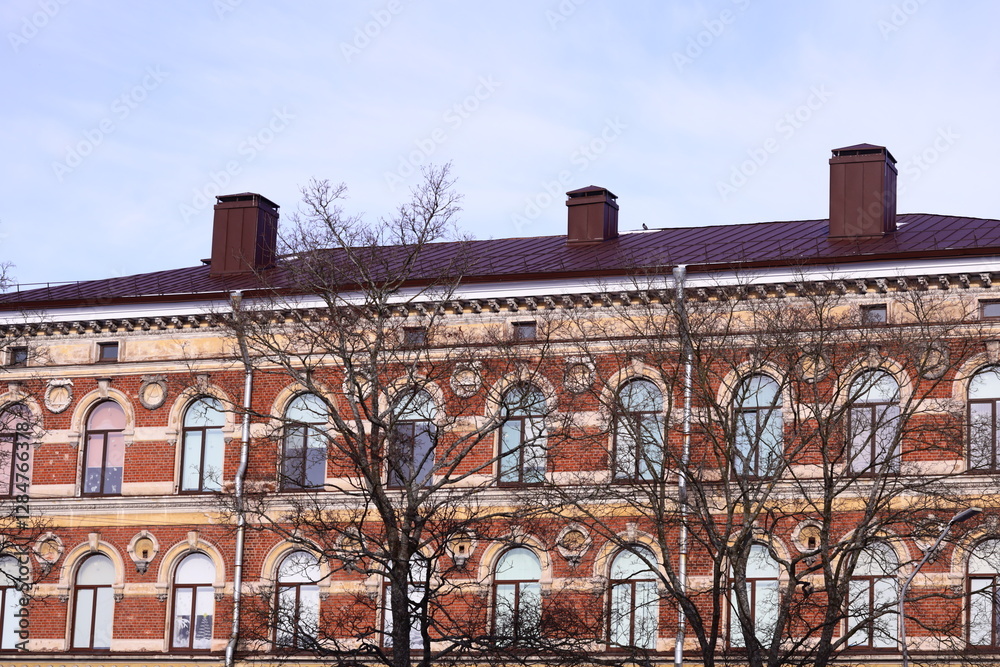 Poster A large brick building with a clock tower, suitable for use in architectural or cityscape scenes.