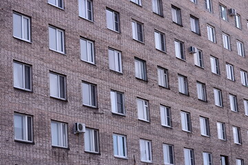 Obraz premium A photograph of a tall brick building with many windows.