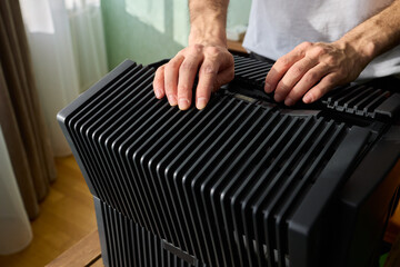 A person diligently assembling a contemporary black cooling device with precision and focus