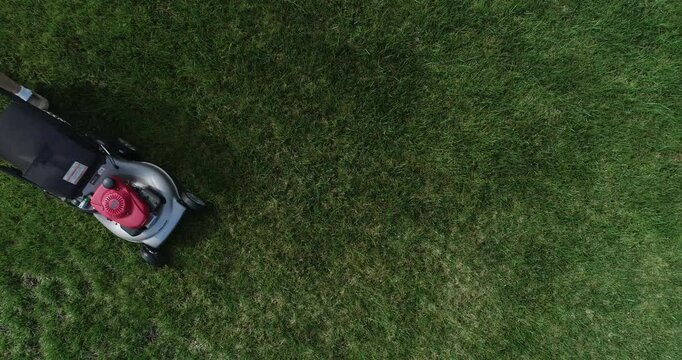 Overhead Hyper-lapse of Man Mowing Fresh Green Lawn on a Summer Day.