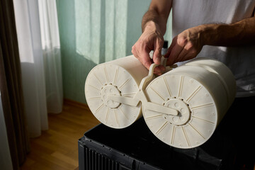 Hands are carefully handling industrial filters while inside a well-organized storage box