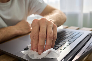 Meticulously Hand Cleaning Your Laptop with a Tissue to Achieve a Fresh and Neat Workspace